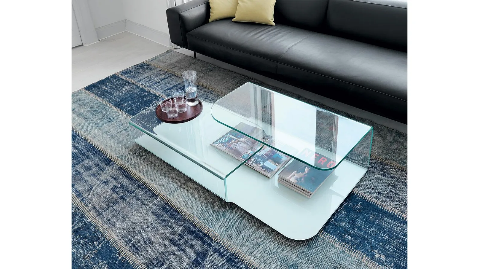 Hug coffee table in transparent curved glass and lacquered glass base by Sovet