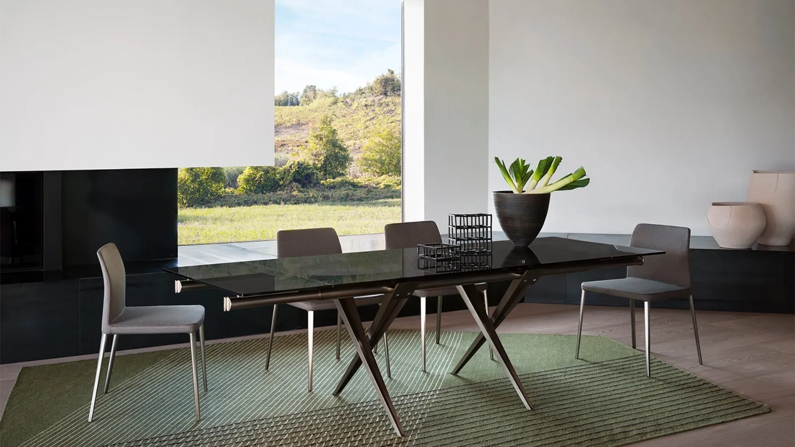 Tender extendable table with glass top and die-cast aluminum legs and steel tubes by Desalto